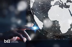 mão apontando para o Brasil em um globo terrestre digital, mostrando o mundo conectado.