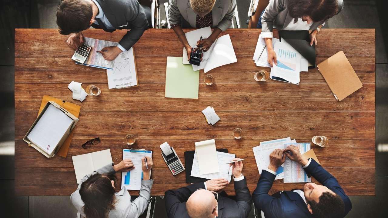 economistas na mesa de reunião que questionam a utilidade do imposto iof